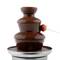 Fontaine au chocolat avec une fraise trempée sur un bâtonnet dans le flux de chocolat.