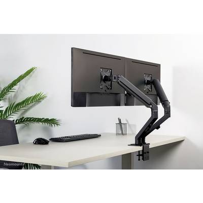 Support de moniteur double, fixé à un bureau, maintient deux écrans horizontalement côte à côte. Sur la table sont visibles un clavier, une souris et une plante.