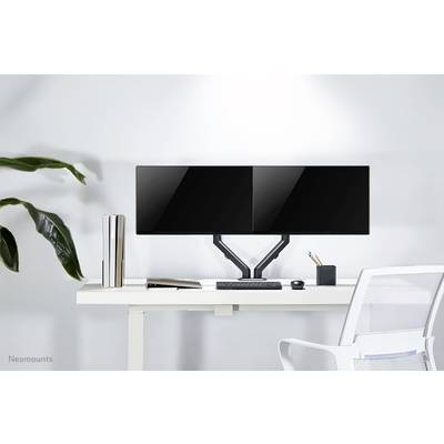Un bureau équipé de deux écrans plats montés côte à côte, avec un clavier, une souris et des plantes, le tout dans un design moderne.