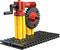 Un modèle de LEGO Technic avec des blocs jaunes, un engrenage rouge et une manivelle, monté sur une plaque de base noire.