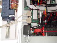 Une console de commande industrielle avec des composants et des cartes de circuits imprimés câblés, établissant une connexion dans un environnement technique.