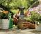 Une personne tient un vaporisateur et en referme le couvercle, entourée de plantes en fleurs sur une table de jardin.