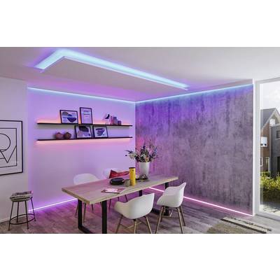 'Un espace repas moderne avec une table en bois et des chaises blanches ; des lumières LED colorées sur les murs et le plafond créent une atmosphère vibrante.'