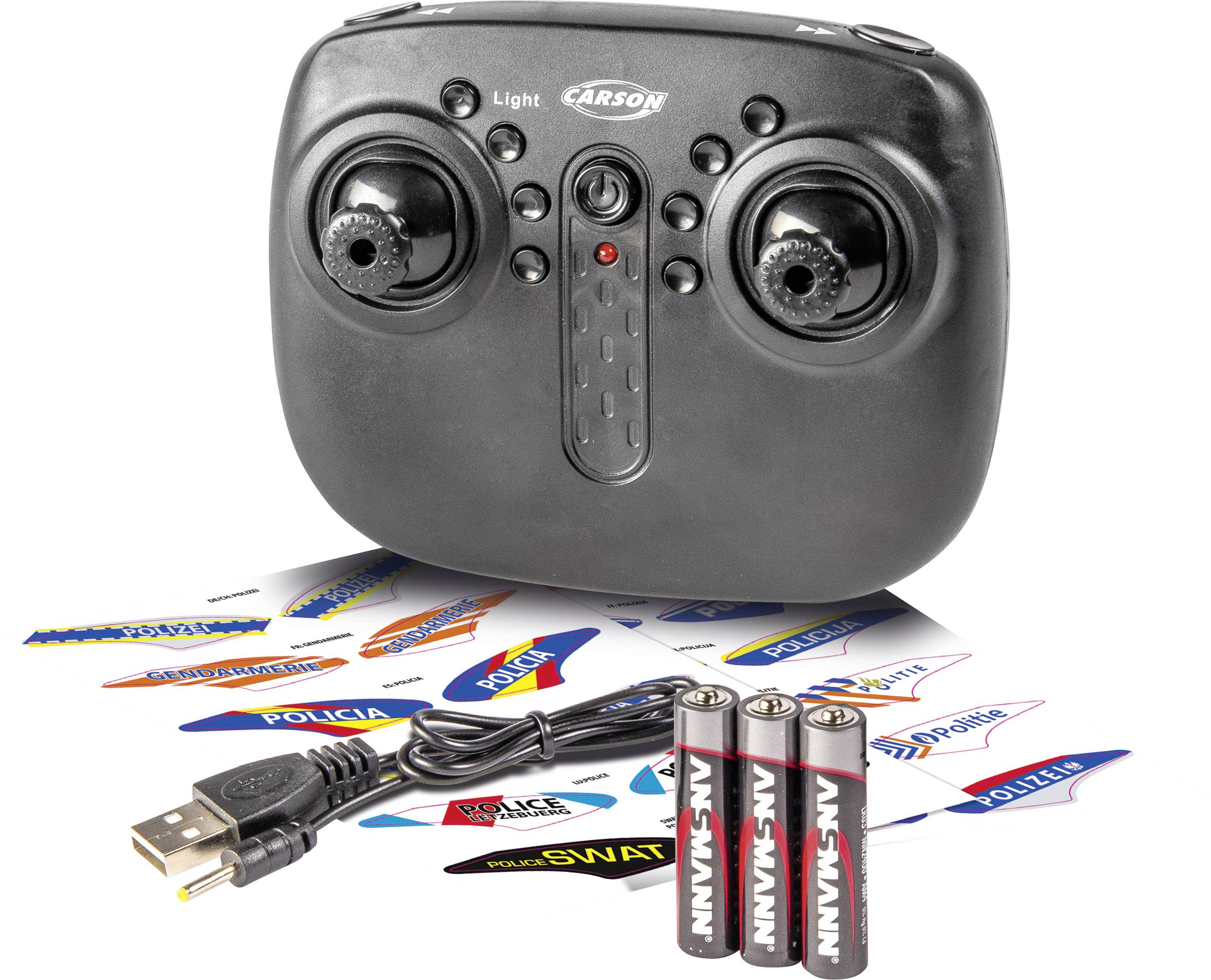 Une télécommande noire avec deux manches de commande, trois piles AA, un câble USB et des autocollants portant différents intitulés de police.