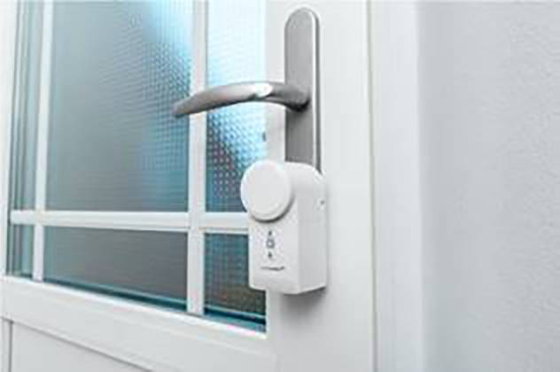 Une serrure intelligente est installée sur une porte blanche. Elle affiche un écran numérique pour les fonctions de verrouillage et déverrouillage.