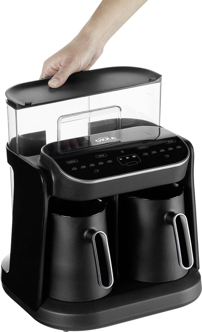 Une personne retire le réservoir d'eau supérieur d'une cafetière moderne noire avec deux carafes.