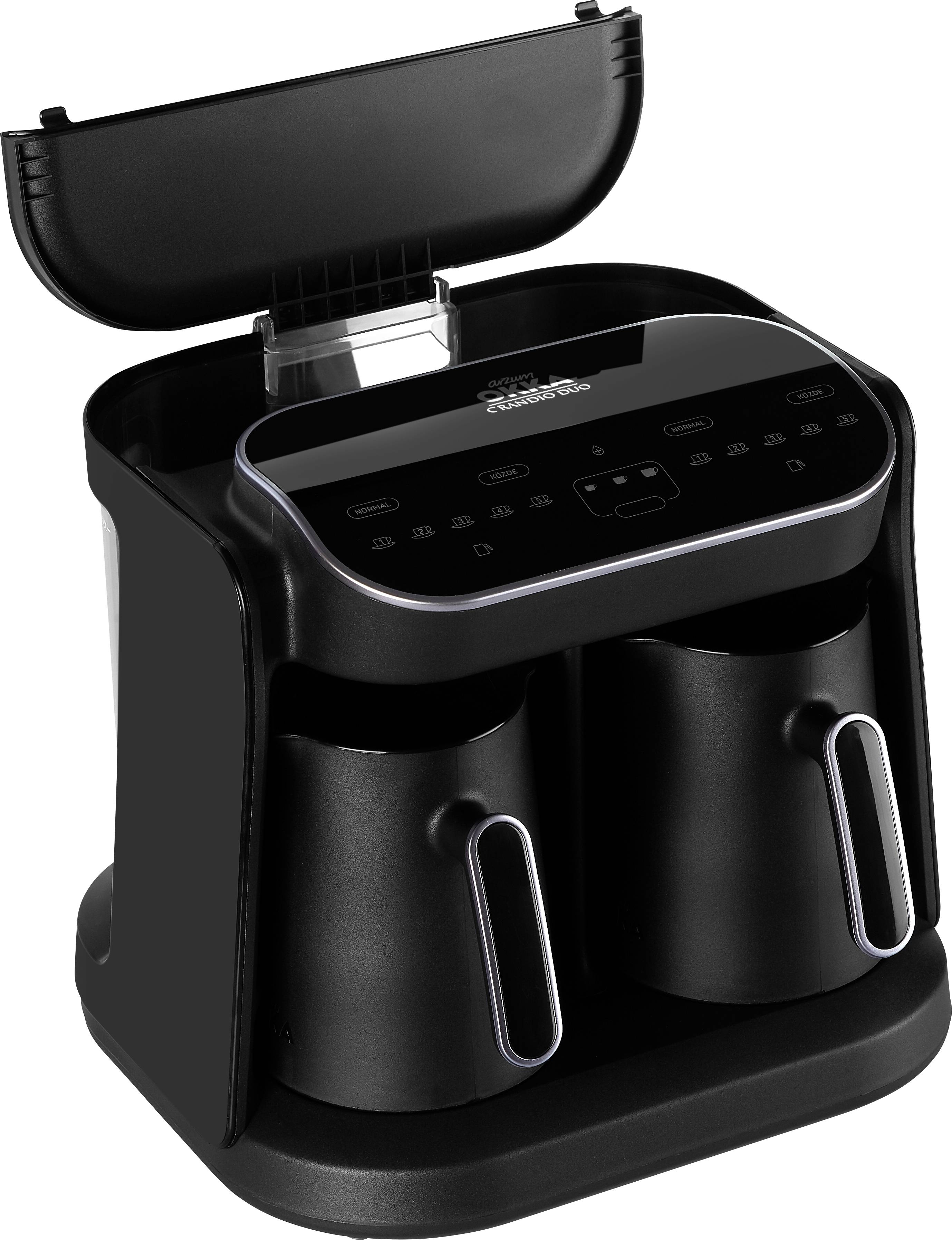 Deux tasses à café noires dans une machine à café moderne avec un panneau de commande numérique.