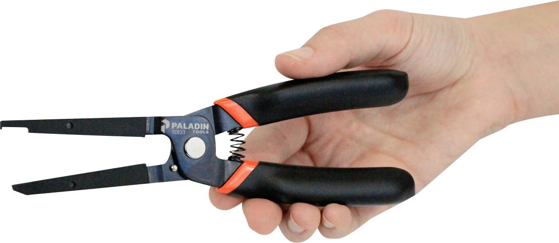 Une main tient un dénudeur, un outil permettant de dénuder les câbles. Il a des poignées noires et une pointe en métal.