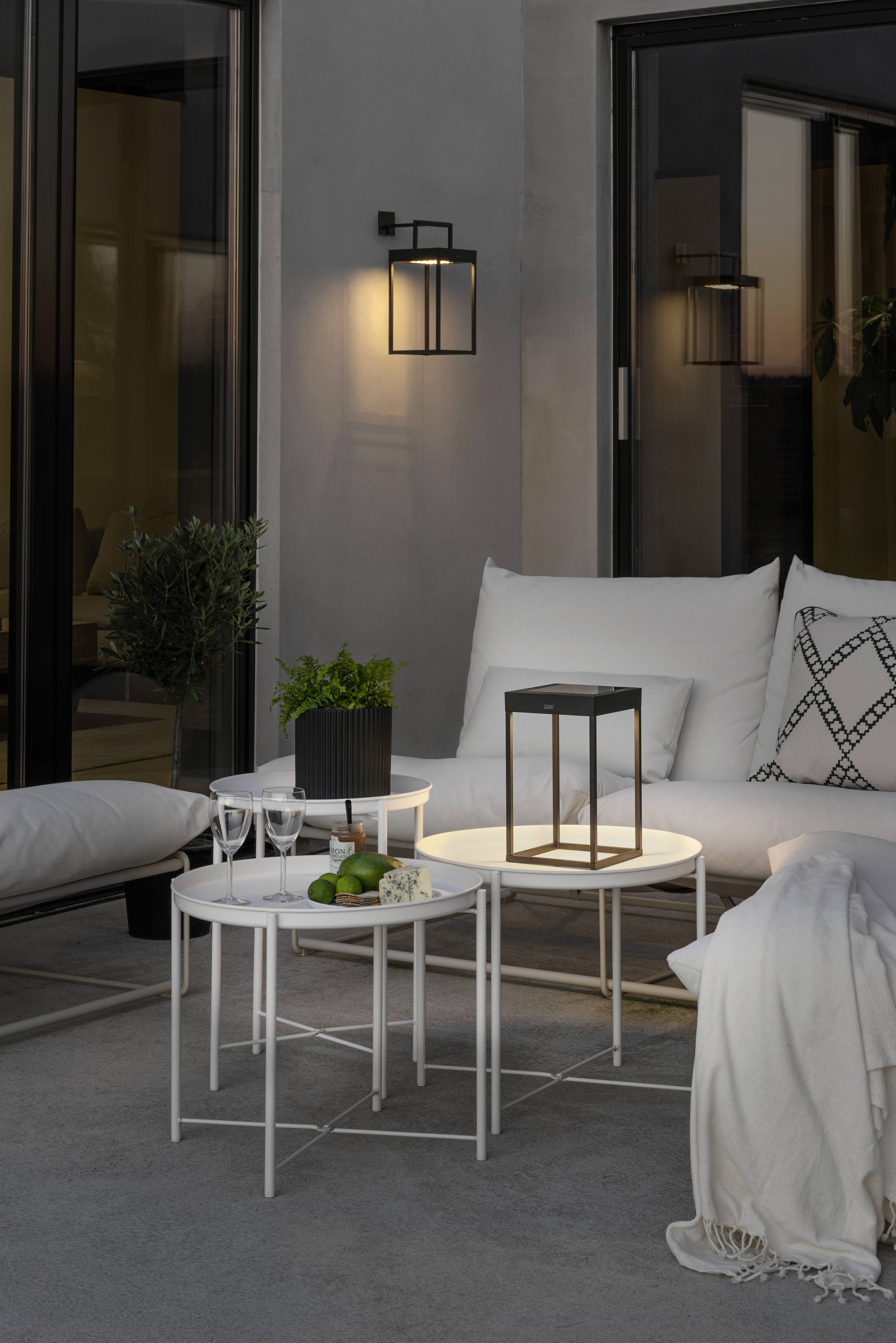 Une terrasse élégante avec des meubles blancs modernes, une petite table et une lanterne décorative. Idéale pour des soirées conviviales.