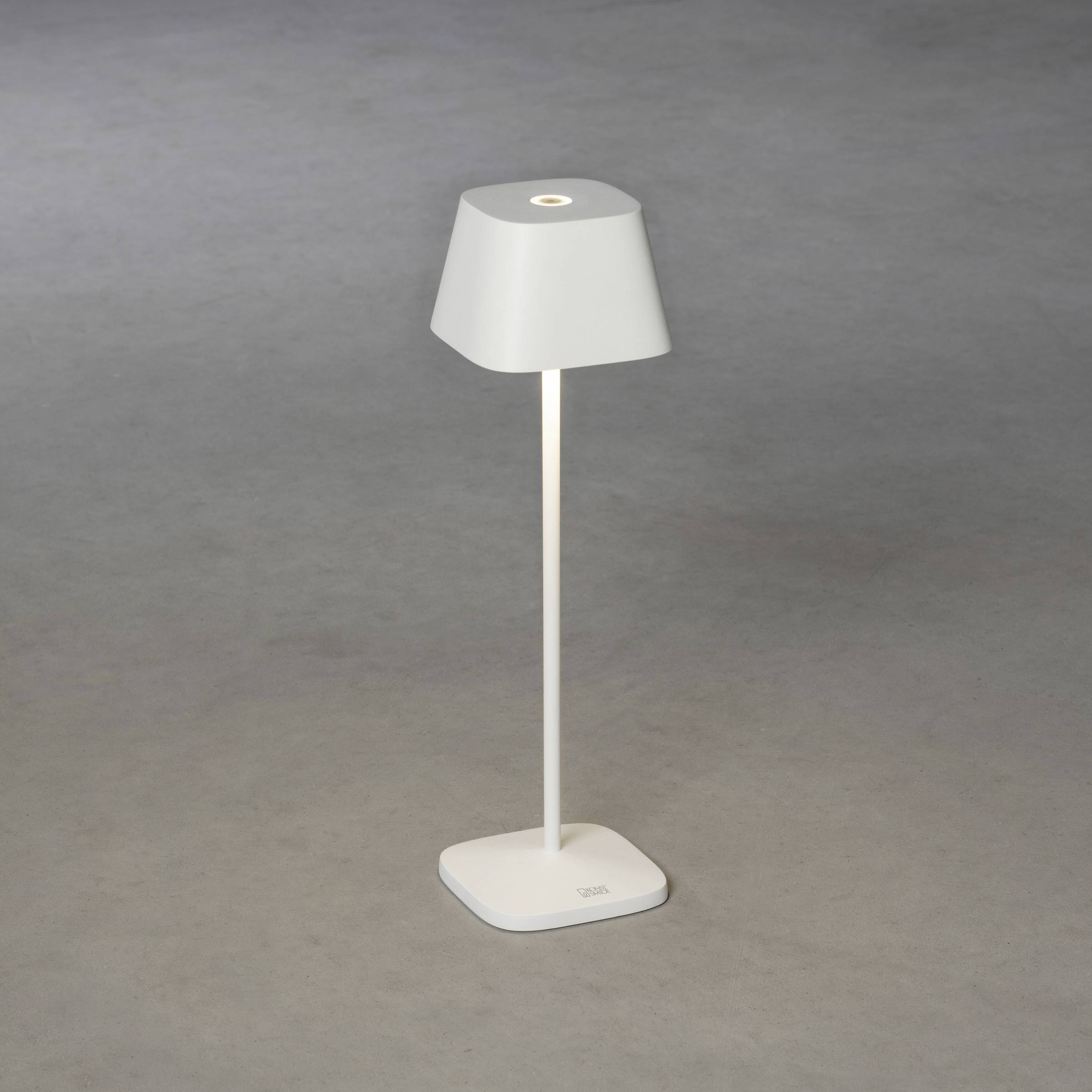 Lampe de table blanche avec abat-jour rectangulaire et support vertical sur fond gris, soulignant un design moderne et minimaliste.