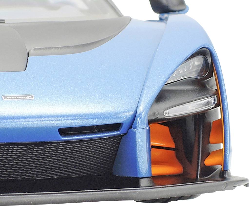 Voiture de sport bleue vue de l'avant, avec des accents orange marquants dans la prise d'air.