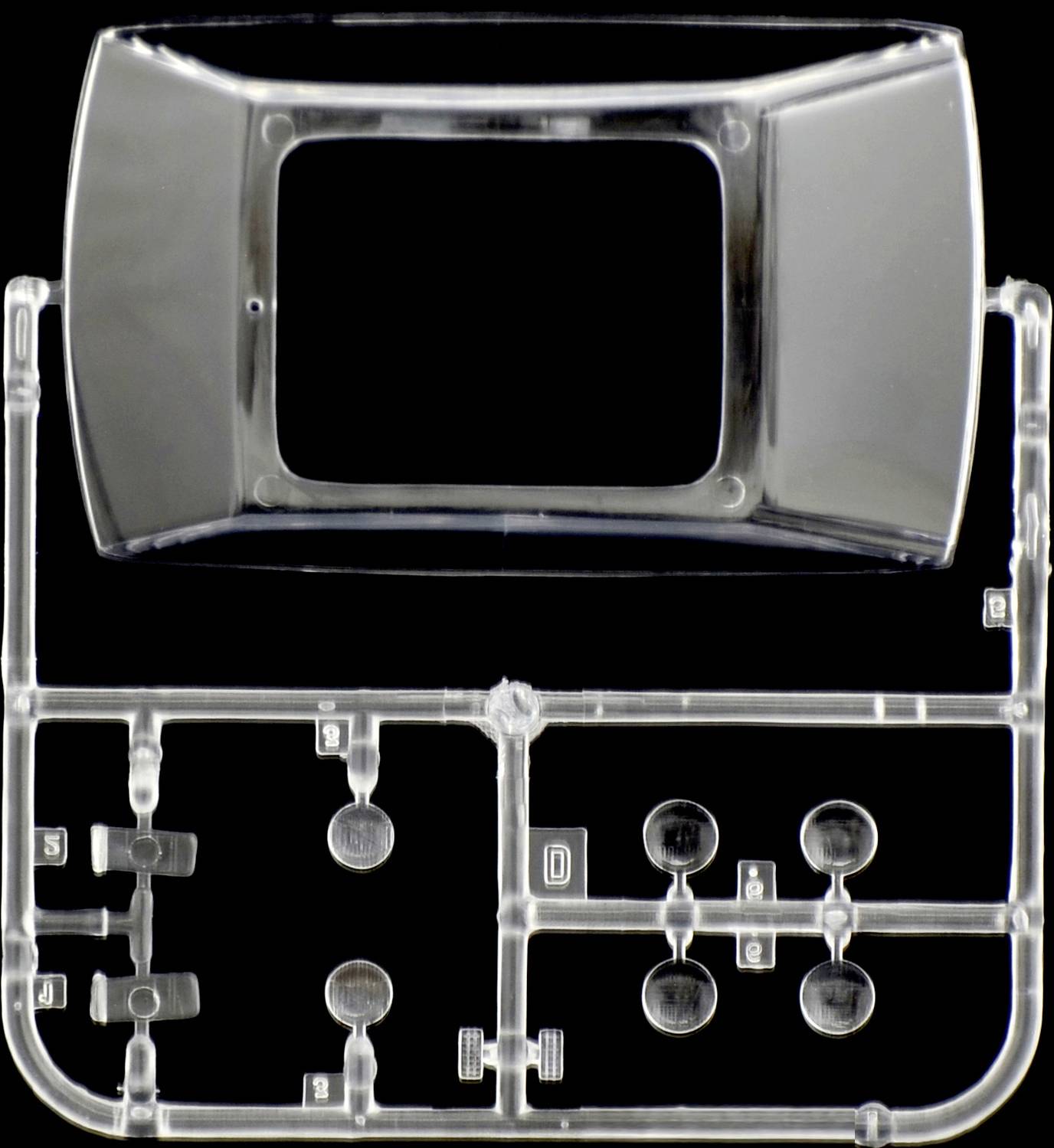 Un kit en plastique transparent avec un cadre rectangulaire, deux pièces bombées en haut et plusieurs petites formes rondes en dessous.