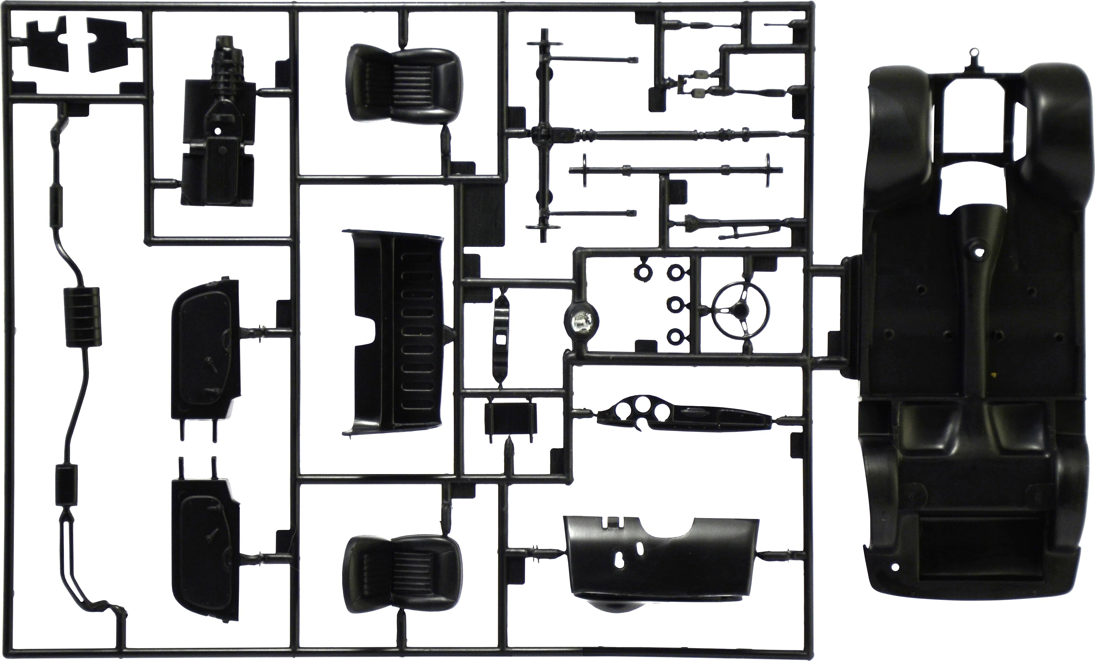 Kit de modélisme avec pièces de voiture noires, comprenant des éléments de carrosserie, des sièges et un volant, disposés sur un châssis grillagé.