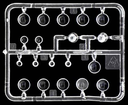 Kit de construction en plastique avec des pièces circulaires transparentes disposées en motif quadrillé. Les pièces sont numérotées et destinées à la maquette.