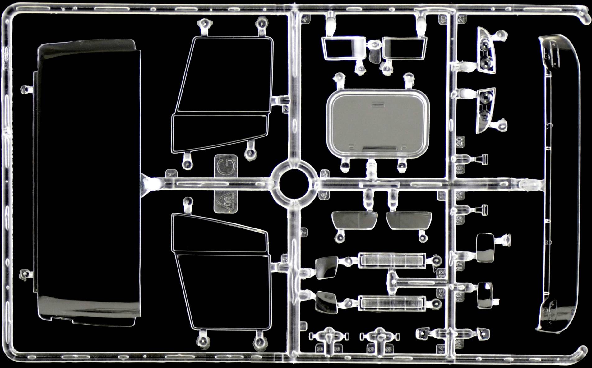 Kit de modélisme automobile transparent avec différentes pièces de véhicule, comprenant des vitres et un spoiler. Les pièces sont disposées en grille.