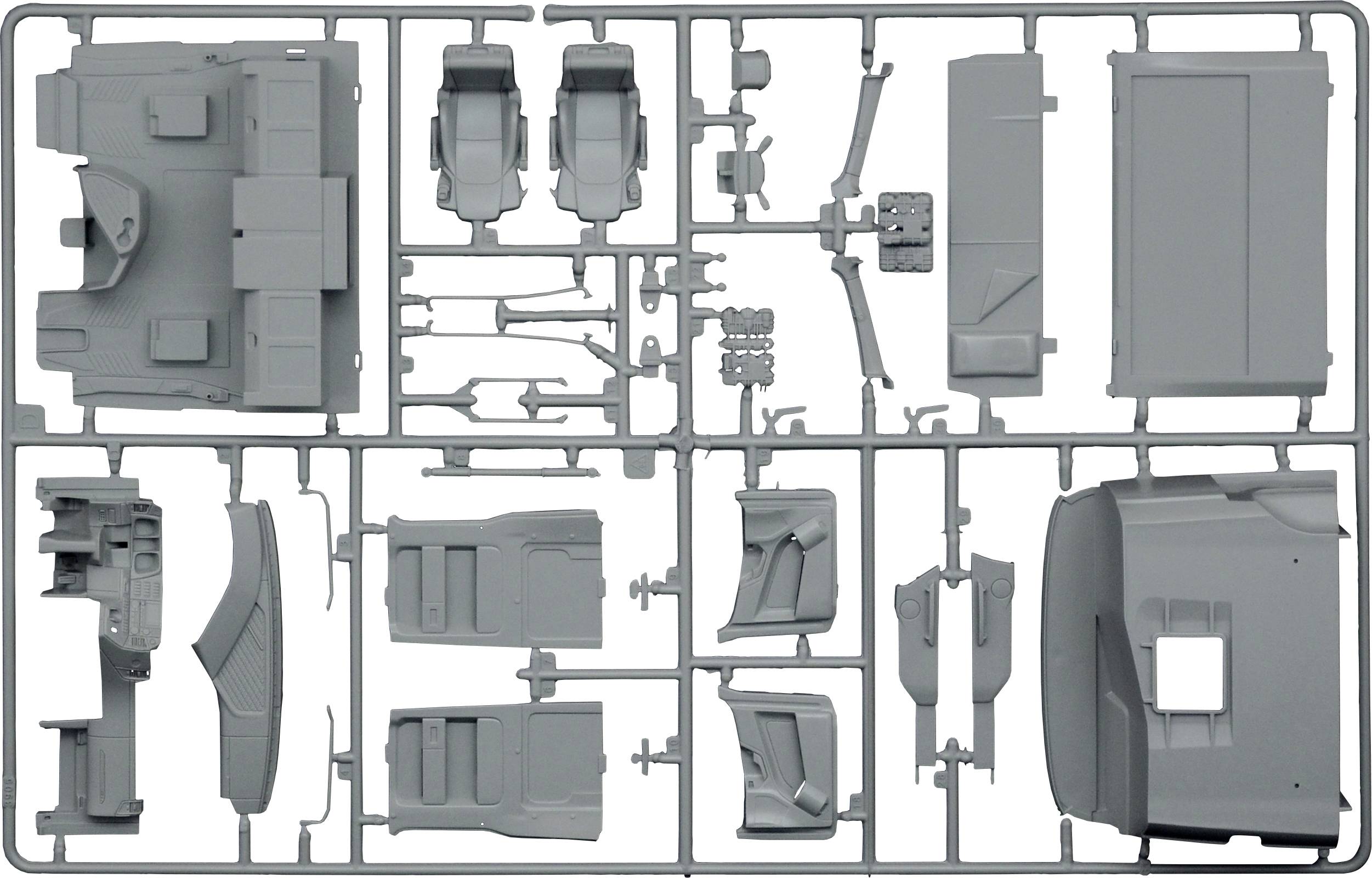 Kit de modélisme en plastique avec de nombreuses petites pièces grises pour un modèle de véhicule. Différentes formes et détails sont visibles.
