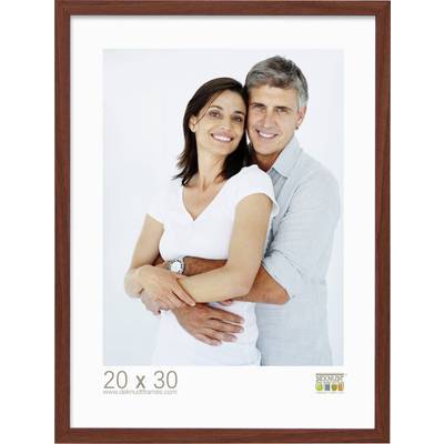 Un couple souriant pose enlacé devant un fond blanc. Ils portent tous deux des vêtements décontractés. En bas, on peut lire : '20 x 30'.
