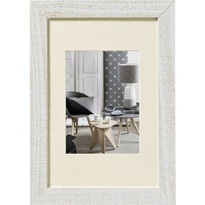 Un salon élégamment aménagé avec une table sur laquelle est posée de la vaisselle ; au fond, un papier peint à pois et une lampe.