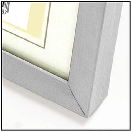 Coin d'un cadre photo argenté avec un passe-partout clair et un encart de code-barres dans le coin supérieur gauche.