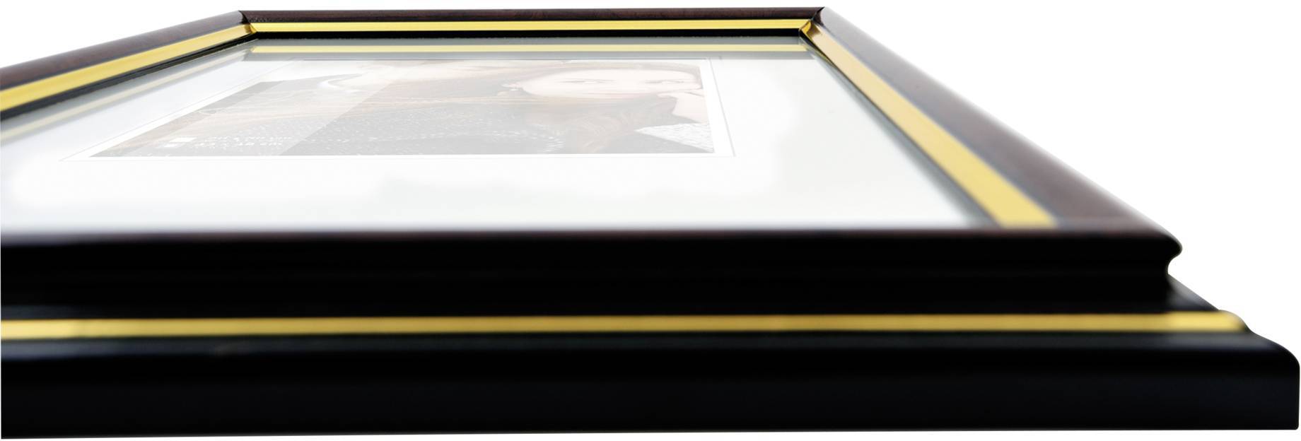 Un angle oblique révèle un cadre rectangulaire en bois avec des touches dorées, encadrant une image représentant une personne.