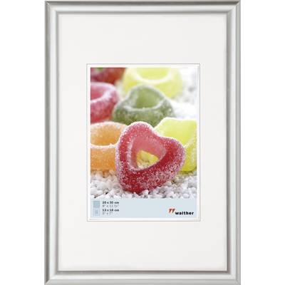 Un cadre photo argenté présente une image de fruits en gelée en forme de cœur, rouge et jaune, saupoudrés de sucre sur un fond blanc.