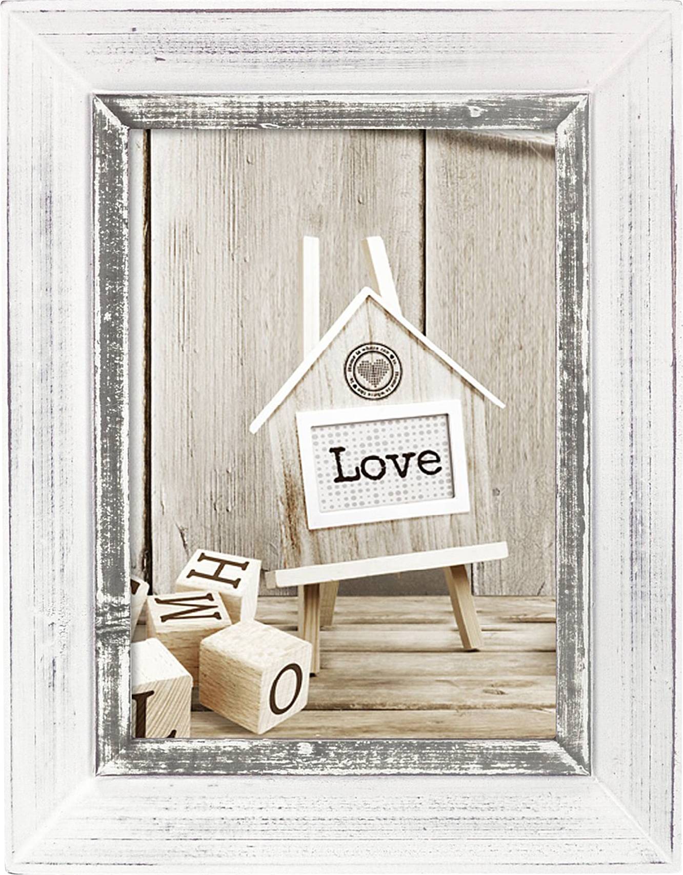 Bordure en bois blanche avec l'image d'une miniature de maison. Sur le devant, il est écrit 'Love'. À côté, des dés avec des lettres sont posés.