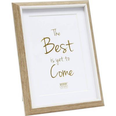 Cadre en bois avec le texte 'Le Meilleur est à venir' en lettres dorées sur fond blanc. Logo de la marque en bas.