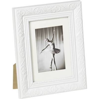 Une photo encadrée montre une ballerine dans une pose élégante sur la pointe des pieds. Le cadre est blanc et décoré.