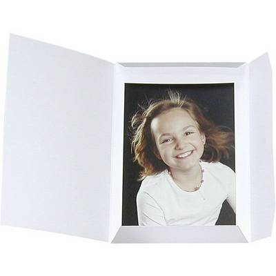 Une fille souriante aux cheveux bruns et à la chemise blanche dans un cadre ouvert.