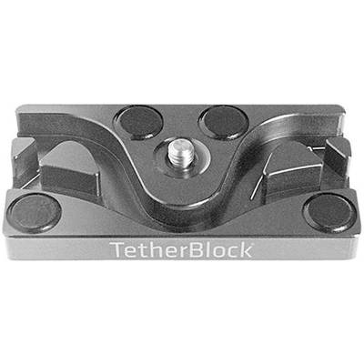 Adaptateur métallique pour guidage de câble, avec une vis au centre. Nom du produit 'TetherBlock' sur la face avant.
