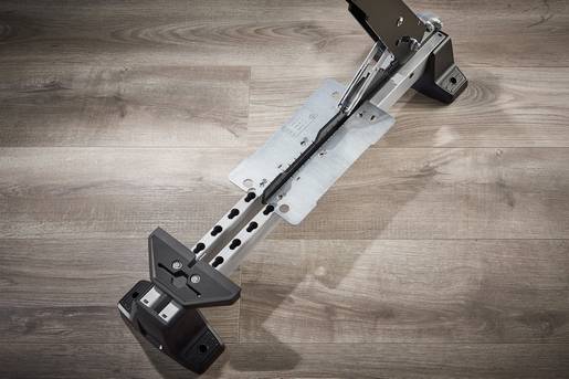 Support mural pour téléviseur sur plancher en bois. Présente les composants en métal et en plastique pour la fixation et l'ajustement.