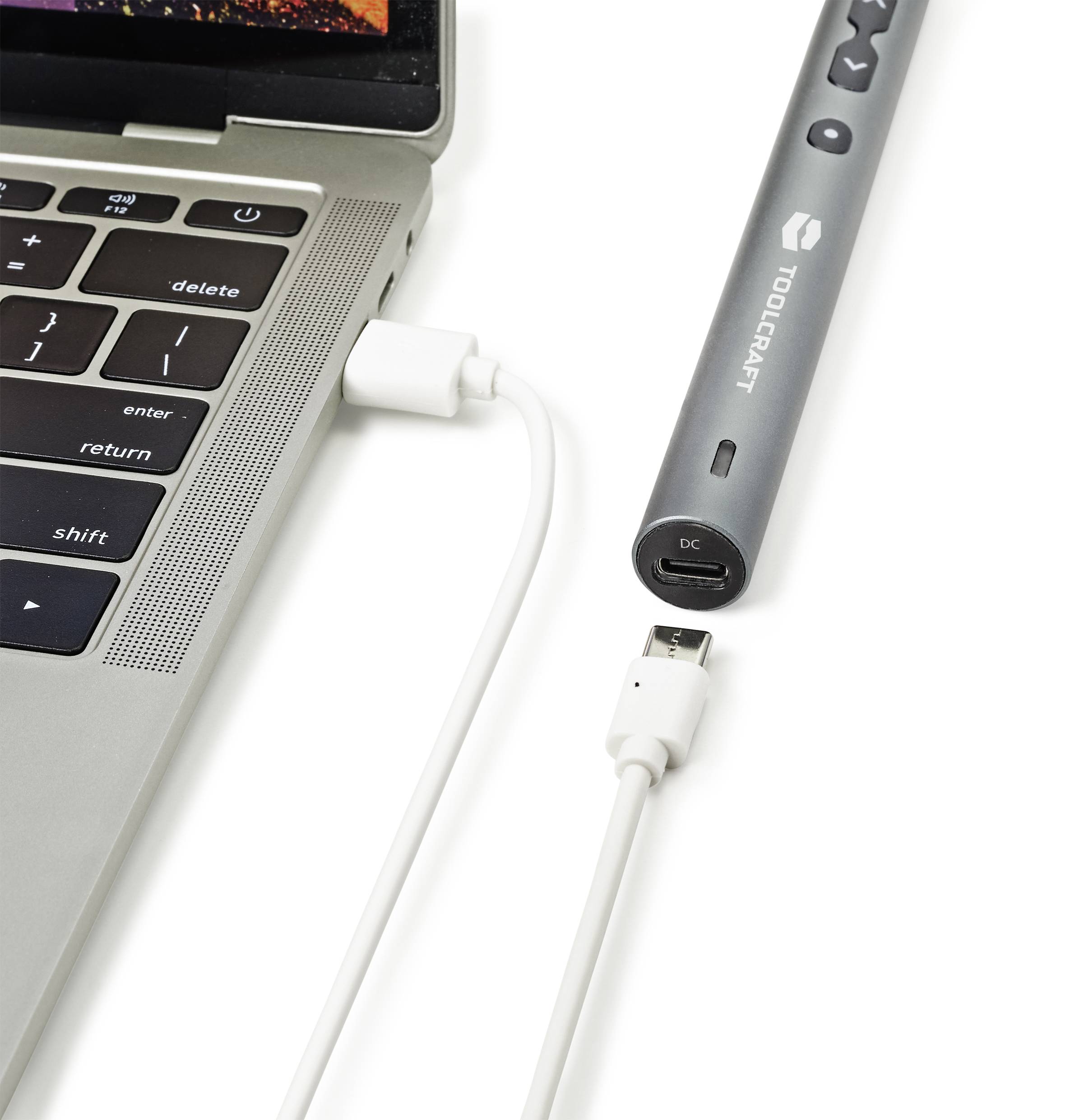 Un clavier d'ordinateur portable est connecté à un appareil électronique gris via un câble USB.