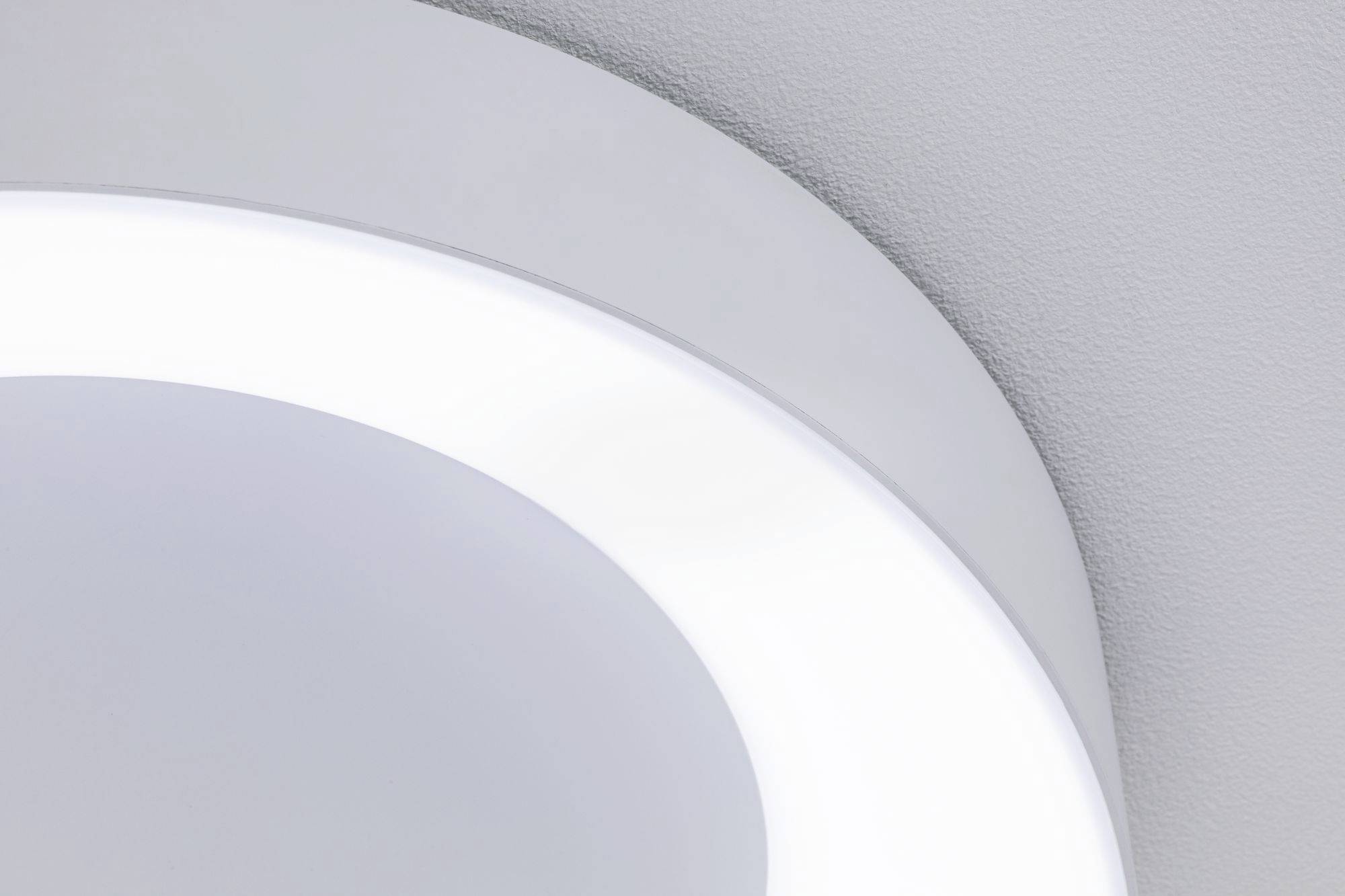 Gros plan d'un plafonnier LED moderne blanc, installé sur un plafond gris, au design circulaire et à la finition lisse.