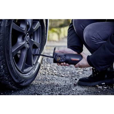 Une personne gonfle un pneu de voiture à l'aide d'un appareil portable. L'appareil affiche les données de pression d'air.