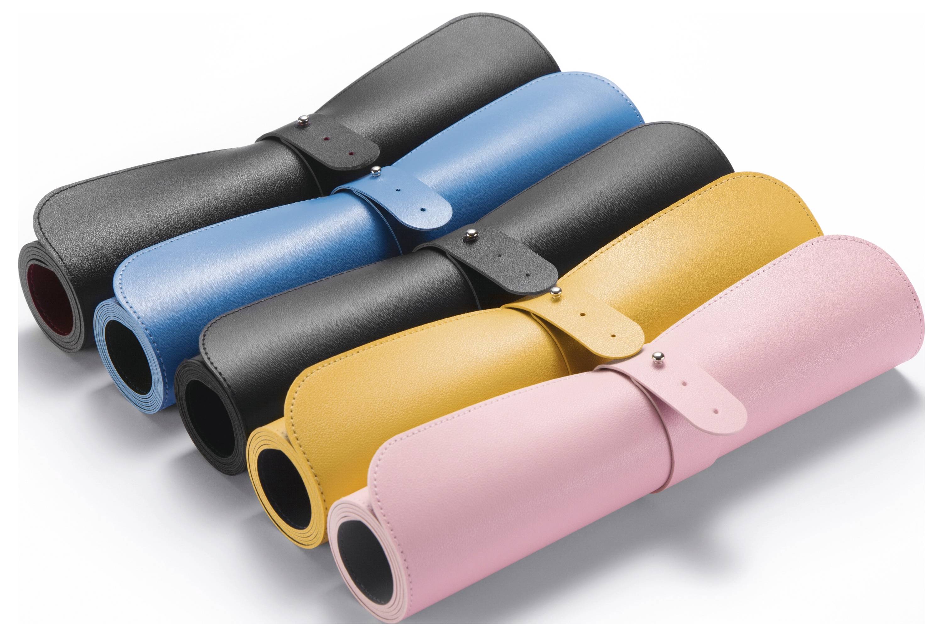Cinq tapis de yoga roulés en noir, bleu, charbon, jaune et rose, empilés en diagonale sur un fond blanc.
