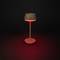 Lampe de table marron avec une lueur rouge dans un environnement sombre, design moderne et minimaliste.
