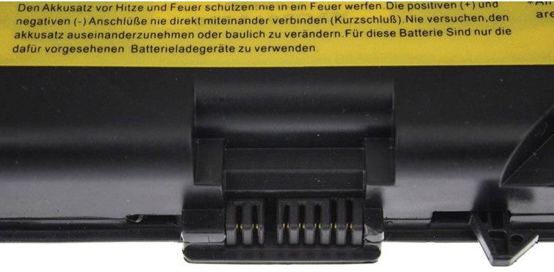 Batterie d'ordinateur portable avec une étiquette jaune d'avertissement qui met en garde contre la chaleur et le feu, et recommande de ne pas connecter ou modifier les bornes.