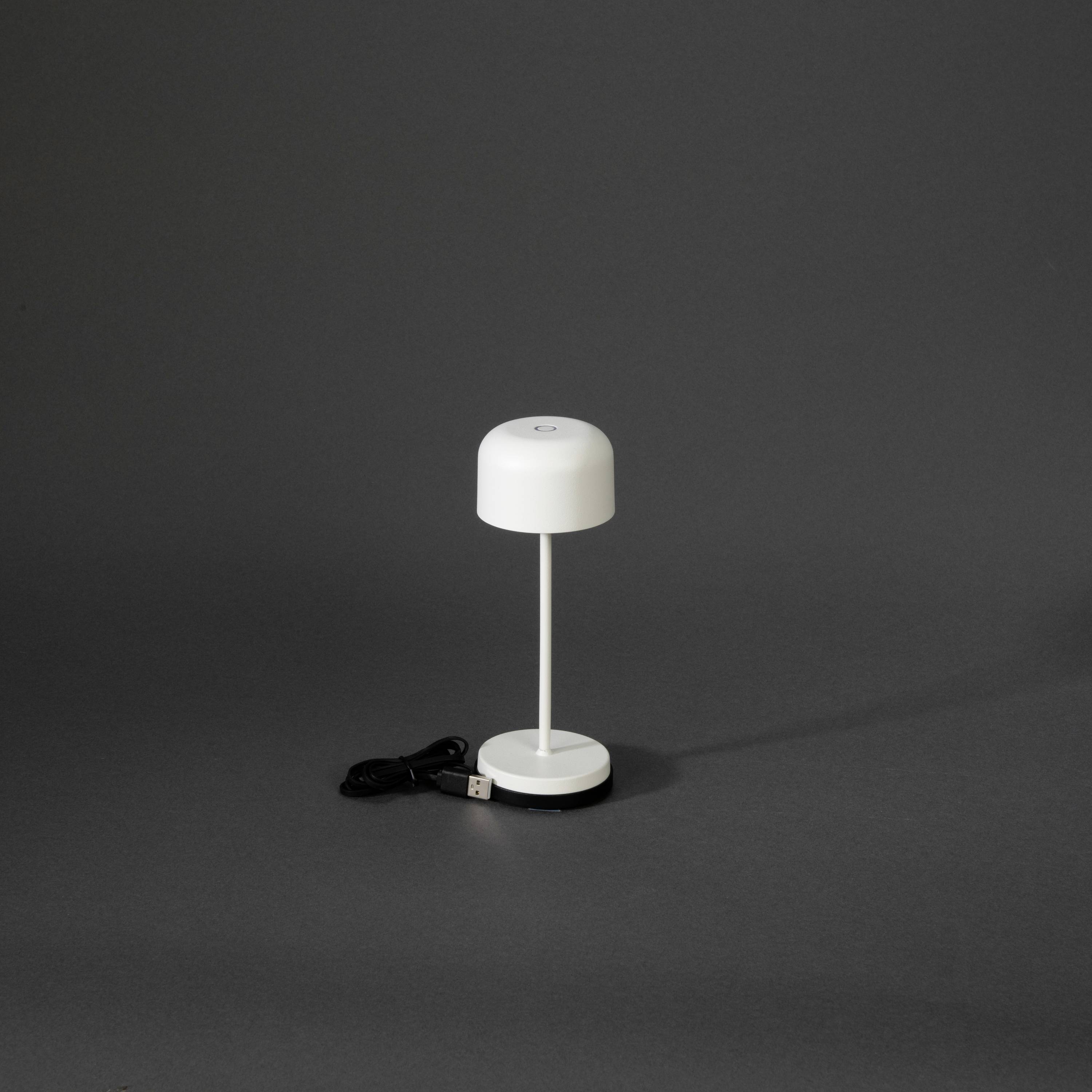 Petite lampe de table moderne avec abat-jour rond et câble USB, sur fond gris.