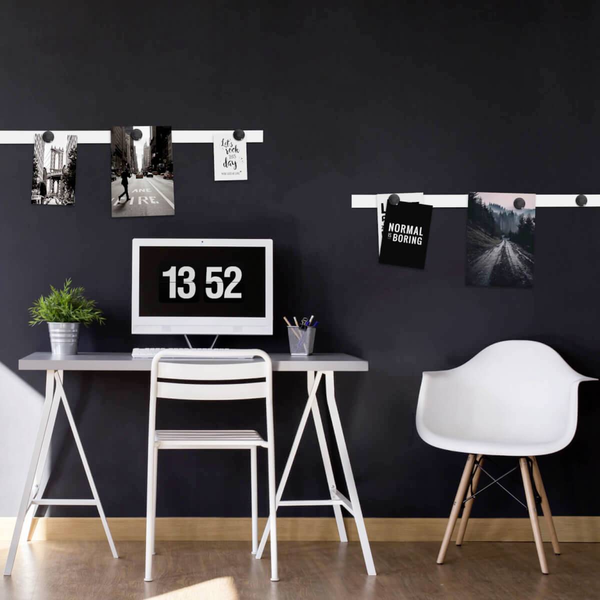 Un bureau moderne avec une chaise, une plante et un écran affiche l'heure '13:52'. Des photos et des notes sont accrochées au mur.