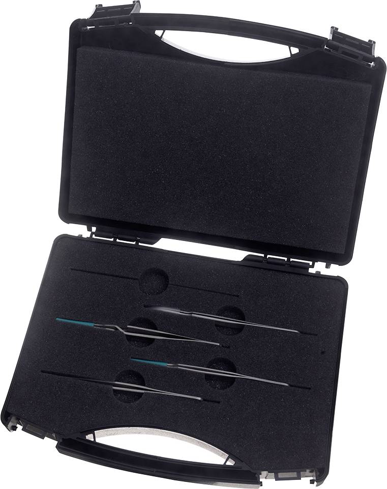 Une valise noire ouverte contenant plusieurs instruments de précision métalliques fins, disposés sur une mousse noire.