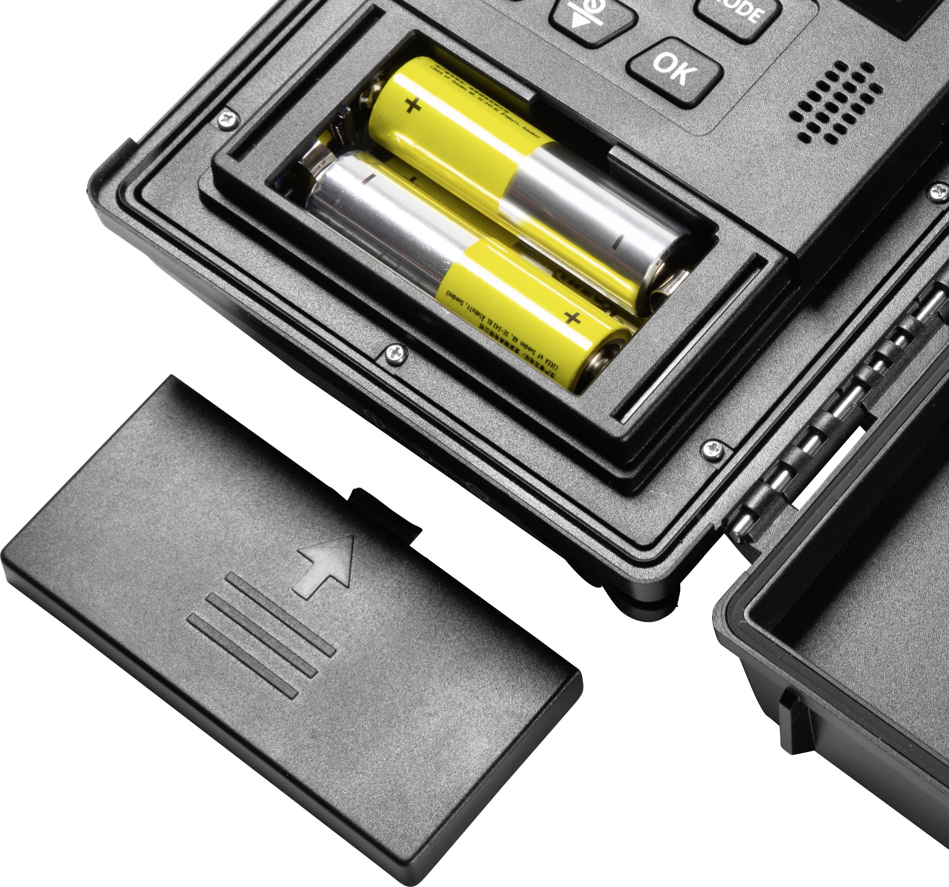 Compartiment de batterie ouvert contenant deux piles AA jaunes dans un appareil électronique, à côté d'un couvercle noir retiré.