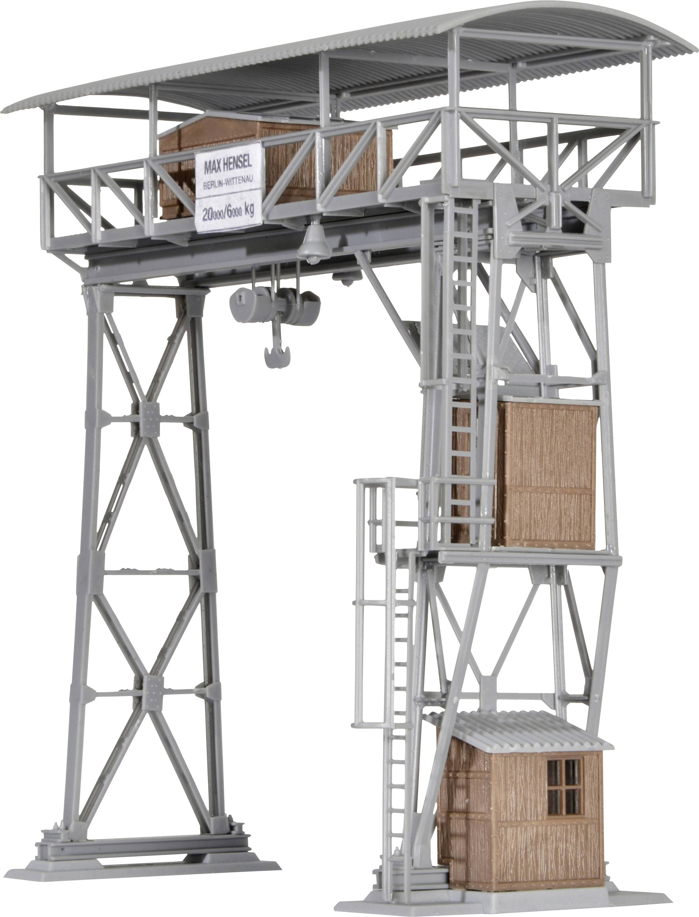 Une grue de modélisme grise en métal et en bois avec un panneau étiqueté. La grue possède une échelle, un câble et une caisse en bois.