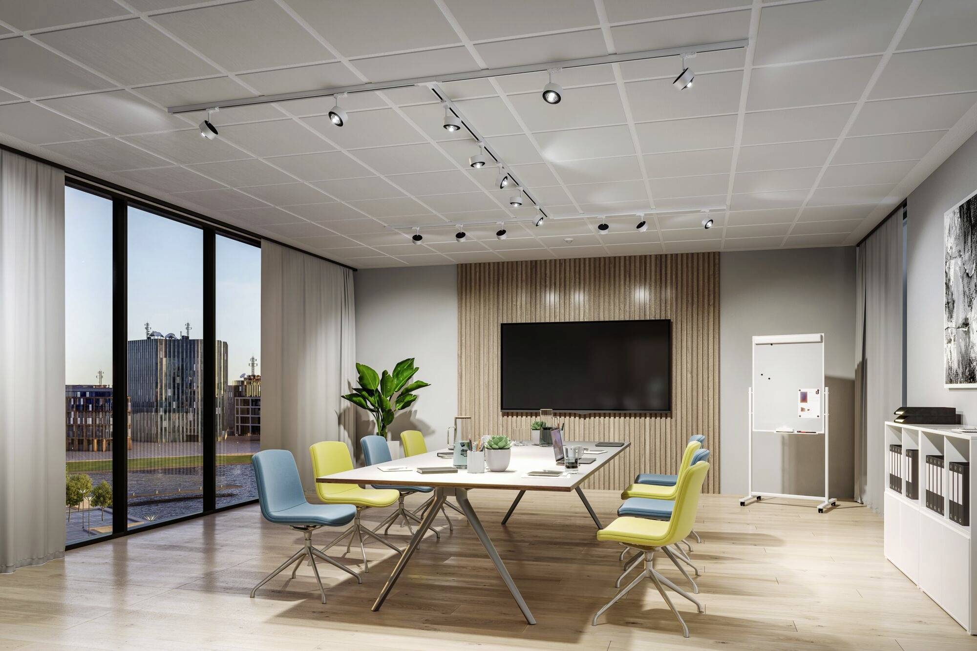 Salle de conférence moderne avec une grande table, des chaises colorées, un grand écran, un tableau à feuilles et de grandes fenêtres offrant une vue panoramique.