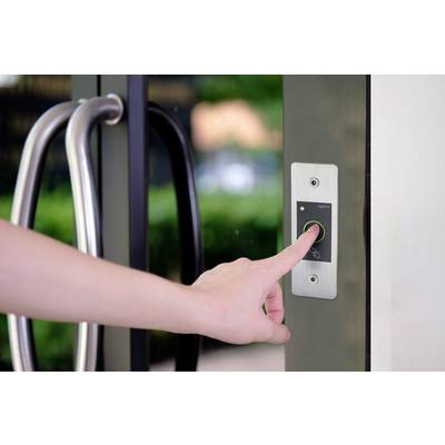 Une main appuie sur un bouton d'un panneau de contrôle d'accès à côté d'une porte vitrée pour ouvrir la porte.