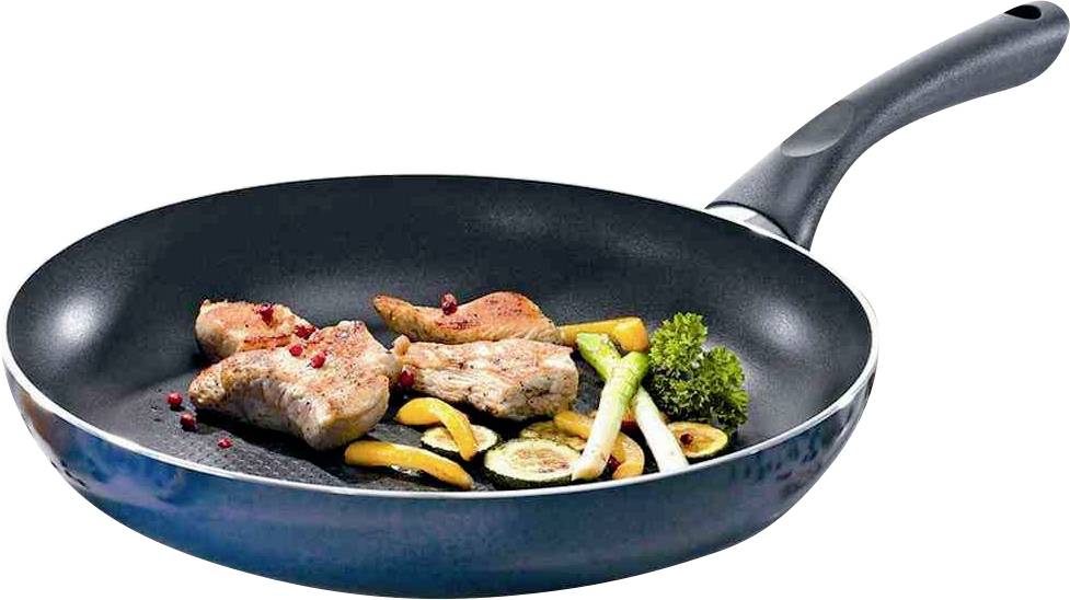 Une poêle avec de la viande rôtie, des poivrons et des oignons verts, prête à être servie sur une cuisinière.