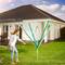 Une femme installe un étendoir à linge dans un jardin ensoleillé. À l'arrière-plan se trouve une maison moderne avec une terrasse.