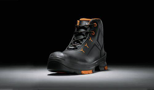 Un chausson de travail noir avec des accents orange sur un fond noir est au centre de l'image.