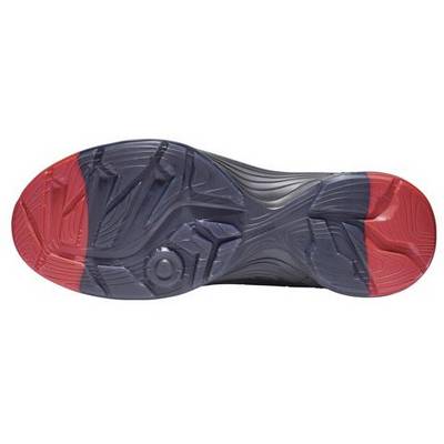Semelle d'une chaussure de sport avec des zones rouges et noires présentant un motif de profil unique pour améliorer l'adhérence au sol.