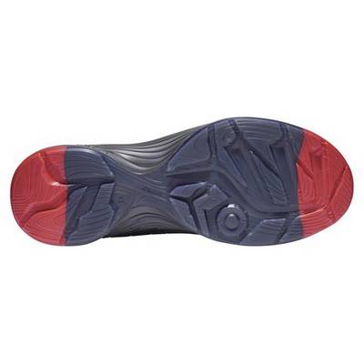 Semelle d'une chaussure de sport avec des éléments bleus et rouges, présentant le motif d'adhérence et le design pour une traction optimale.