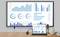 Un écran et une tablette affichent des analyses graphiques avec des diagrammes et des pourcentages qui visualisent différentes données.
